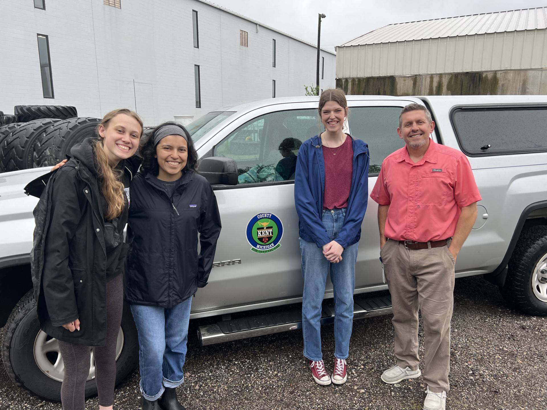 4 people standing in front of truck that has Kent County logo on the side